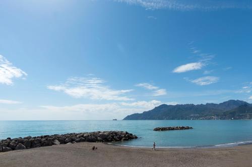 a beach with people on the sand and rocks in the water at Dulce Mare in Salerno