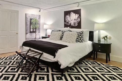 a bedroom with a large bed and a black and white rug at Under The Red Door On Monterey in Savannah