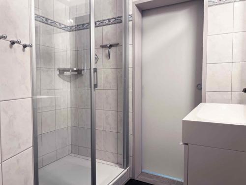 eine Dusche mit Glastür neben einem Waschbecken in der Unterkunft Idyllische Ferienwohnung Schmidt 9226 - Burg in Fehmarn