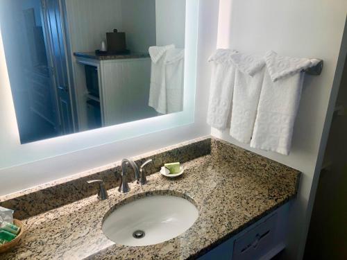a bathroom with a sink and a mirror and towels at Beach View Hotel in Rehoboth Beach
