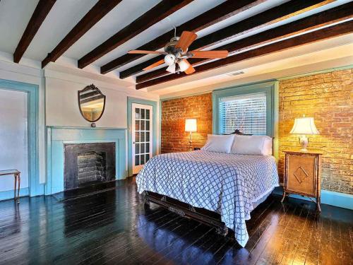 um quarto com uma cama e uma parede de tijolos em Diplomat House em Savannah