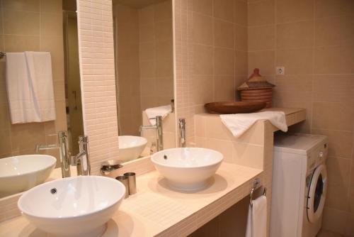 a bathroom with two sinks and a washing machine at Santa Maria Main Street in Santa Maria