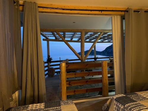 a bedroom with a view of the ocean from a window at Hamre Apartments (Nicholas) in Agios Georgios Pagon