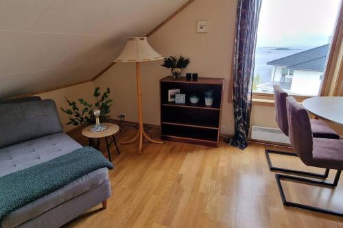 a living room with a couch and a table and a lamp at Central apartment with a view! in Harstad