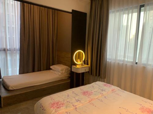 een slaapkamer met 2 bedden en een lamp erin bij lmperio Residence Melaka - Private Indoor Hot Jacuzzi in Melaka