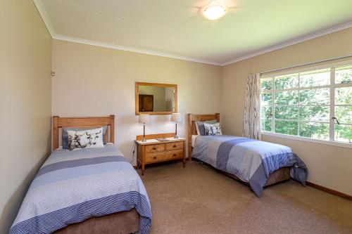 a bedroom with two beds and a window at Lowestoffe Country Lodge Rockford in Hogsback