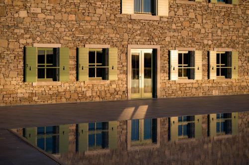 a building with windows and a reflection in a pool of water at Winery & Design hotel ROXANICH in Motovun