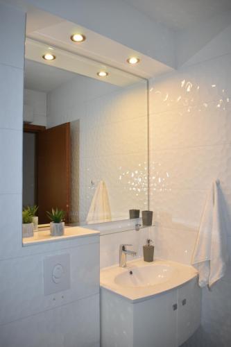 Baño blanco con lavabo y espejo en Apartment Aria Split en Split