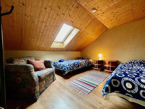 Kurdla的住宿－Laimjala Guesthouse with a Cozy Lounge and Terrace，阁楼卧室配有1张床和1张沙发