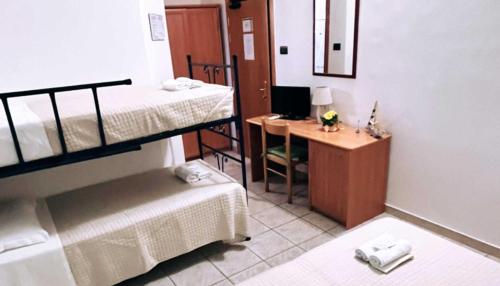 a room with two bunk beds and a desk with a computer at Hotel Valente in Ortona