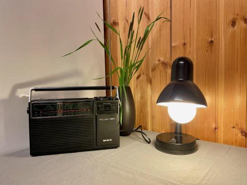 a table with a lamp and a radio next to a lamp at Laimjala Guesthouse with a Cozy Lounge and Terrace in Kurdla