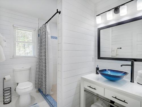 a bathroom with a sink and a toilet and a mirror at Deja Blue B in Tybee Island