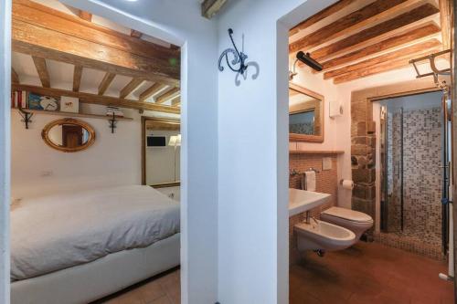 ein Schlafzimmer mit einem Bett und einem Waschbecken sowie ein Badezimmer in der Unterkunft La Finestrella in Cortona