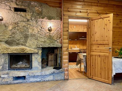 - un salon avec une cheminée en pierre dans une maison dans l'établissement Laimjala Guesthouse with a Cozy Lounge and Terrace, à Kurdla