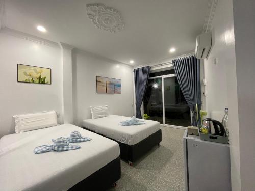 a hotel room with two beds and a television at Mother’s House in Battambang