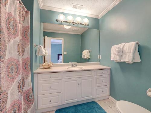 een badkamer met een wastafel en een spiegel bij Lola's Retreat in Tybee Island