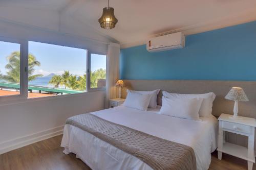 um quarto com uma cama e vista para o oceano em Chez Louise et Louis Pé na Areia em Juqueí