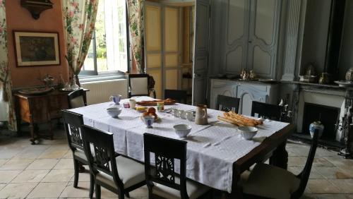 uma sala de jantar com uma mesa com comida em Chambre aux coccinelles em Cosne-Cours-sur-Loire