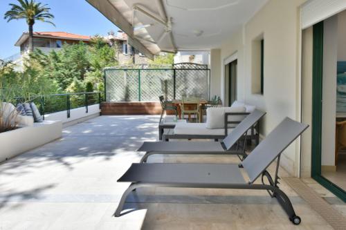 d'un balcon avec des chaises et une table sur une maison. dans l'établissement Stunning 3-Br Apartment with Large Terrace and Pool, à Cannes