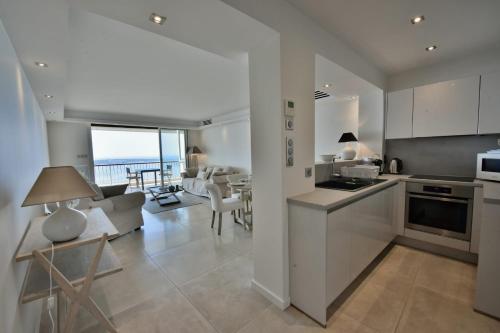 a kitchen and living room with a view of the ocean at Apartment in a 8 hectares park incredible view in Cannes