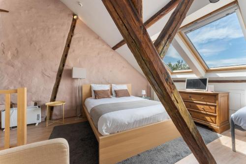 - une chambre mansardée avec un lit et un bureau dans l'établissement Lake Suites, à Bruges