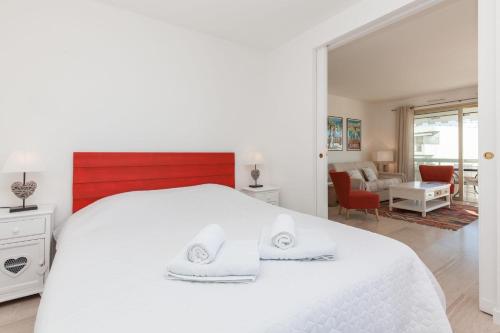 a white bedroom with a white bed and a living room at SERRENDY Sea view & terrace heart of Cannes in Cannes