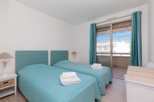 two twin beds in a room with a window at SERRENDY Sea view & terrace heart of Cannes in Cannes