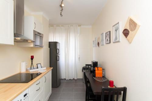 La cuisine est équipée d'un comptoir, d'une table et d'un réfrigérateur. dans l'établissement 2-Br Apartment 2 min from the Beaches, à Cannes