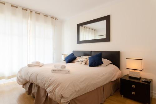 une chambre avec un lit avec un miroir au mur dans l'établissement 2-Br Apartment 2 min from the Beaches, à Cannes