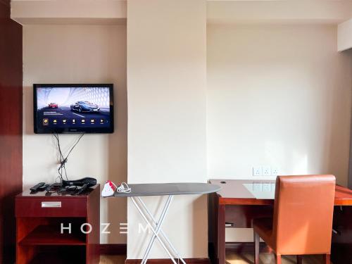 a room with a table and a tv on the wall at SBR2B Hozem KK1184 Apartment CBD in Kota Kinabalu