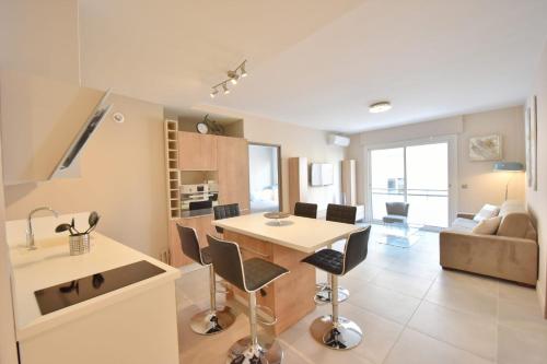une cuisine et un salon avec une table et des chaises dans l'établissement 3-Room Apartment in the Heart of Cannes, à Cannes