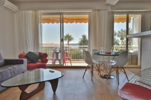 a living room with a couch and a table at Facing the sea modern terrace near the beaches in Cannes