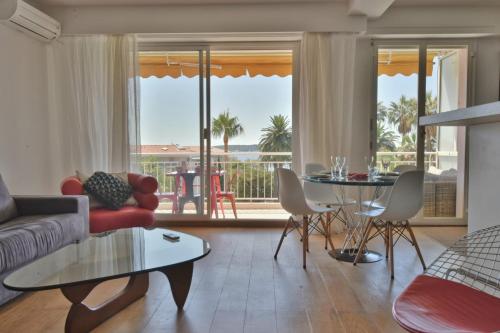 un salon avec un canapé et une table dans l'établissement 1-Br Apartment Sea View Steps from Beaches, à Cannes
