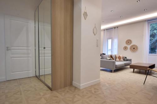 un salon avec un canapé et un miroir dans l'établissement Modern 3-Br Apartment in City Center 5 Minutes from Palais and Beache, à Cannes