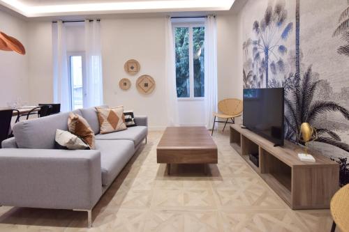 un salon avec un canapé et une télévision dans l'établissement Modern 3-Br Apartment in City Center 5 Minutes from Palais and Beache, à Cannes