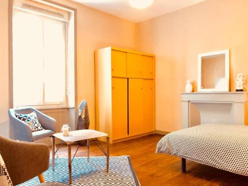 a bedroom with a yellow cabinet and a bed and a fireplace at LE ORANGE - Confort - Wifi - Entre Gare et Centre in Quimper