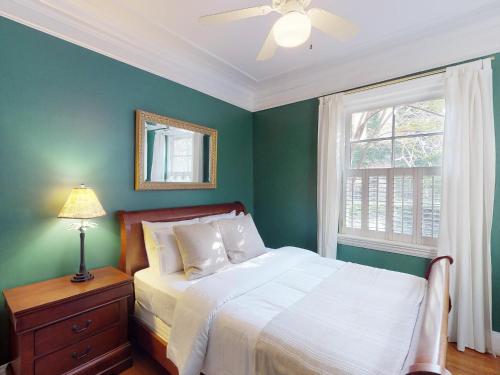 Dormitorio verde con cama y ventana en Southern Charm on Liberty, en Savannah