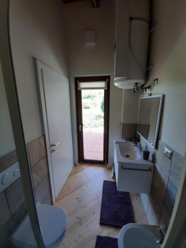 baño con lavabo, espejo y puerta en CASA BRACCALDI en Peveragno