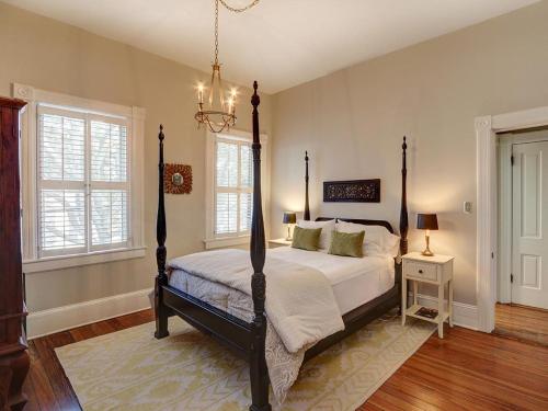 een slaapkamer met een bed en een kroonluchter bij Luxury on Lincoln in Savannah