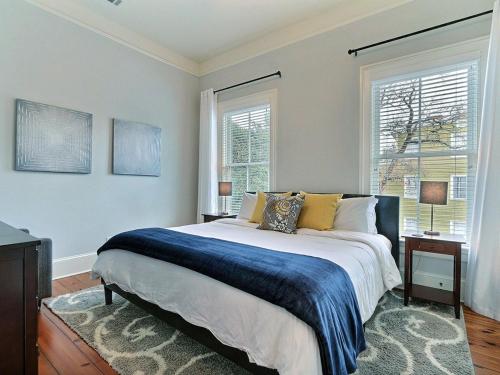 1 dormitorio con 1 cama grande y 2 ventanas en Southern Exposure, en Savannah
