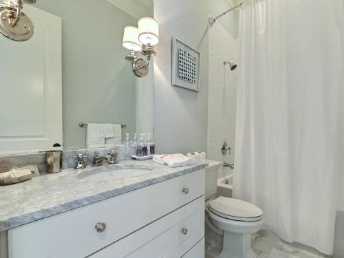 Baño blanco con lavabo y aseo en Southern Exposure, en Savannah