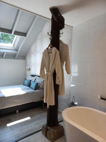 een badkamer met een bad en een bed bij Schaapskooi in Dwingeloo