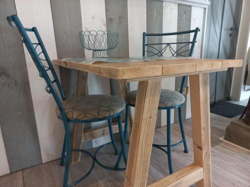 a wooden table with two chairs and a table with a table at Schaapskooi in Dwingeloo