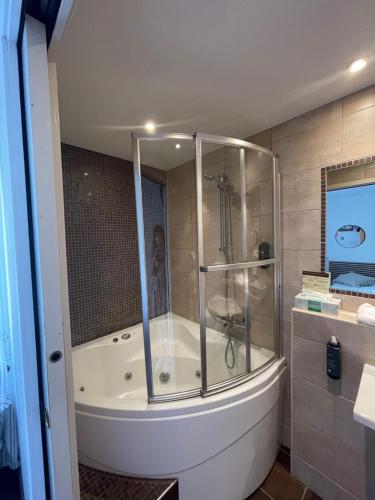 a bathroom with a shower and a bath tub at Hôtel Ulysse Montpellier Centre in Montpellier
