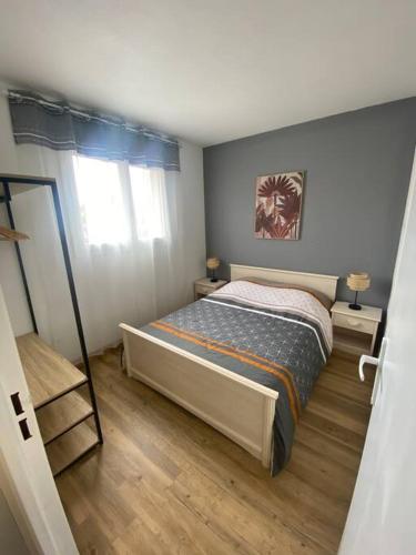 une petite chambre avec un lit et une fenêtre dans l'établissement Charmant F3 400 m de la plage, à Argelès-sur-Mer