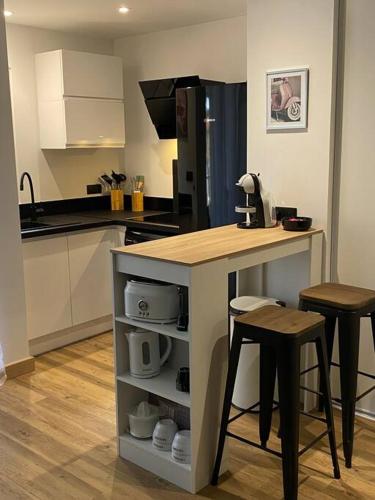 une cuisine avec une table, deux tabourets et un comptoir dans l'établissement Charmant F3 400 m de la plage, à Argelès-sur-Mer