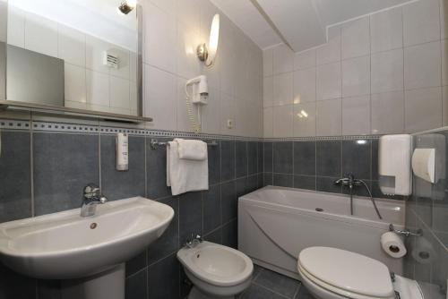 ein Badezimmer mit einem Waschbecken, einem WC und einer Badewanne in der Unterkunft Hotel Tolero in Ploče