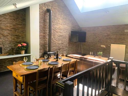 a dining room with a wooden table and chairs at La Maison Ardoise in Herbeumont