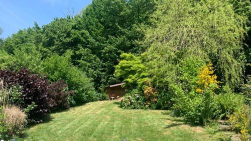 a house in the middle of a field with trees at La Maison Ardoise in Herbeumont