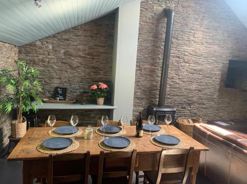 una mesa de madera con platos azules y copas de vino en La Maison Ardoise, en Herbeumont